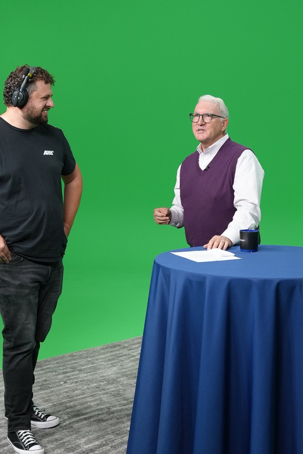 A crew member wearing a headset talking with an Ohio BWC presenter in the studio
