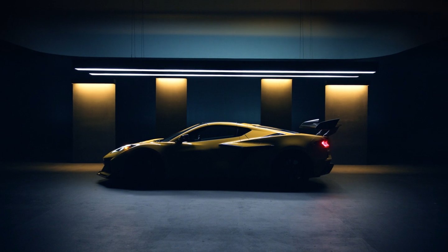 Yellow Corvette in profile against a dark studio setting