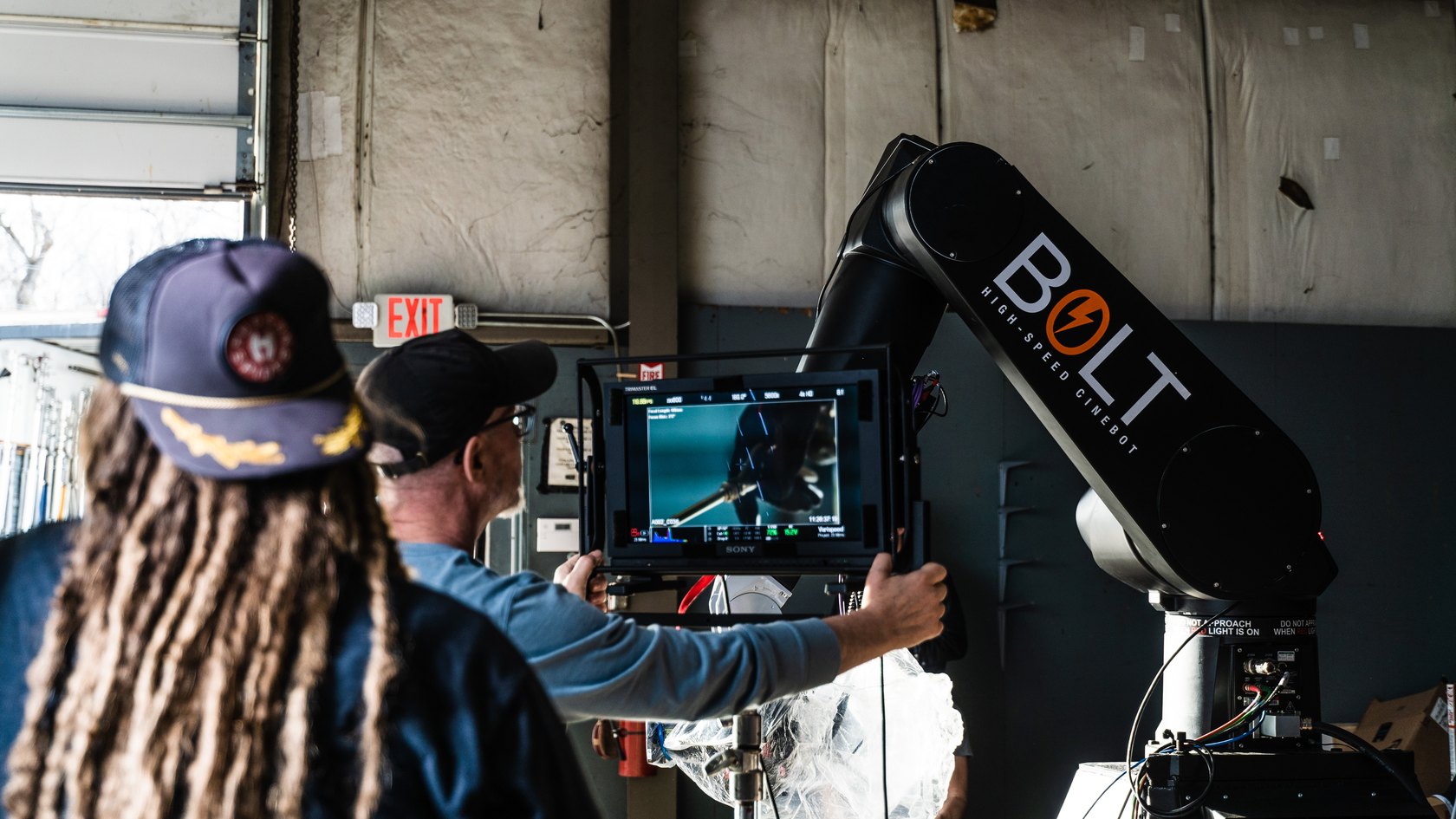 Crew reviewing a monitor beside a Bolt Cinebot