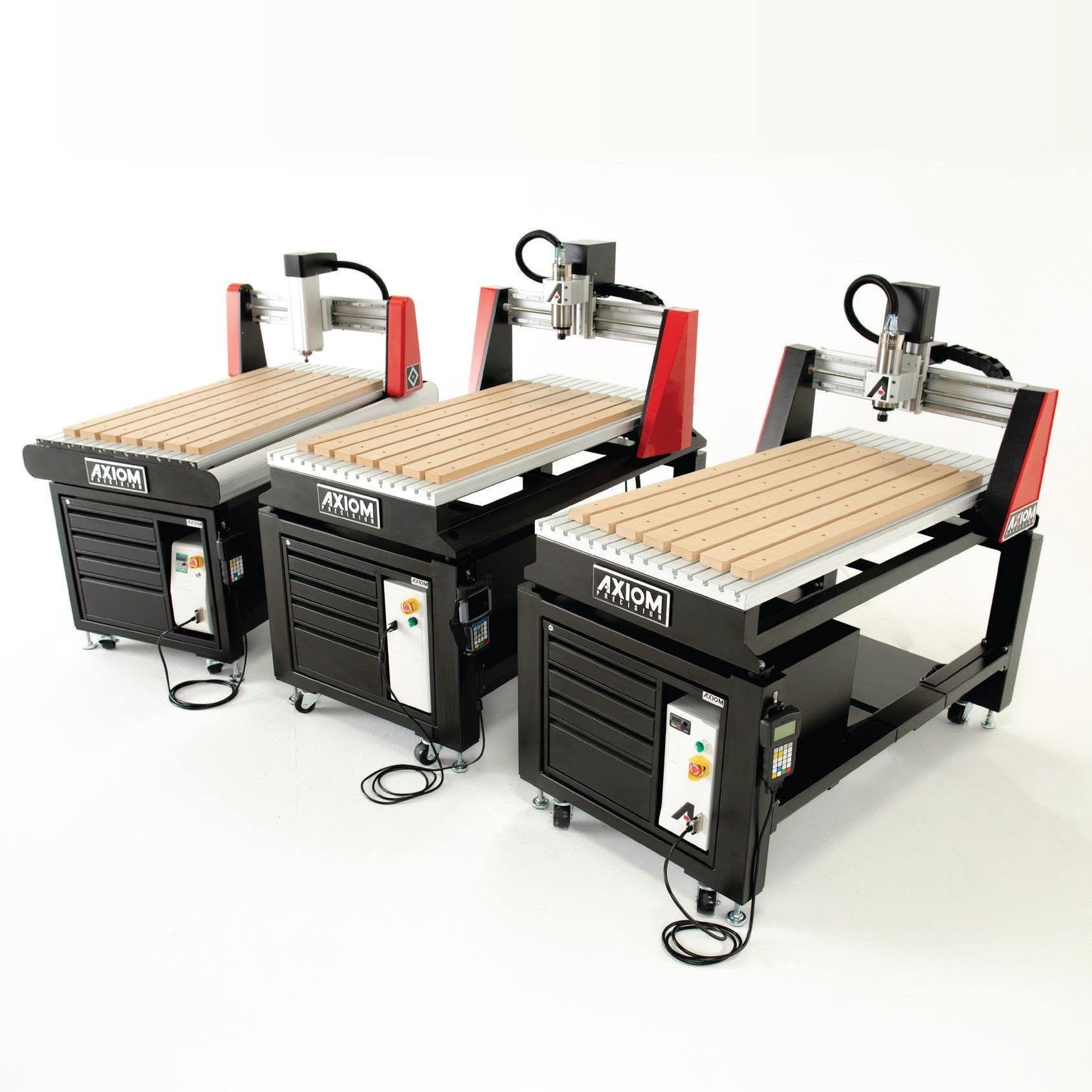 Three Axiom CNC routers arranged side by side