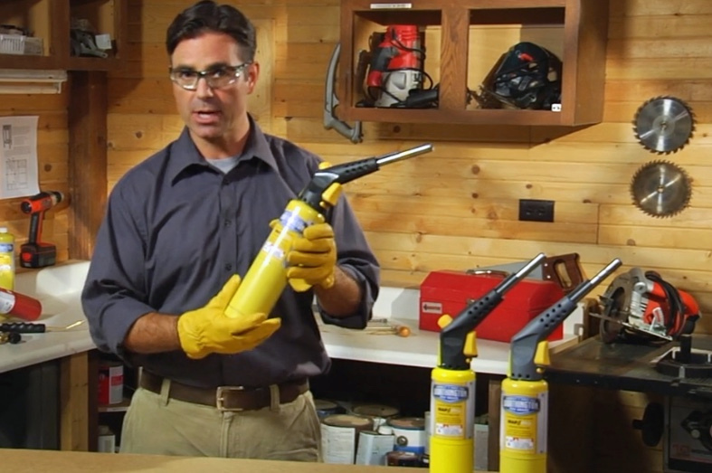 A technician demonstrates a handheld torch in a workshop