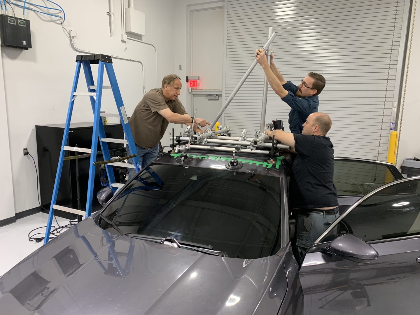 Crew building a camera mount above a Honda at the test track