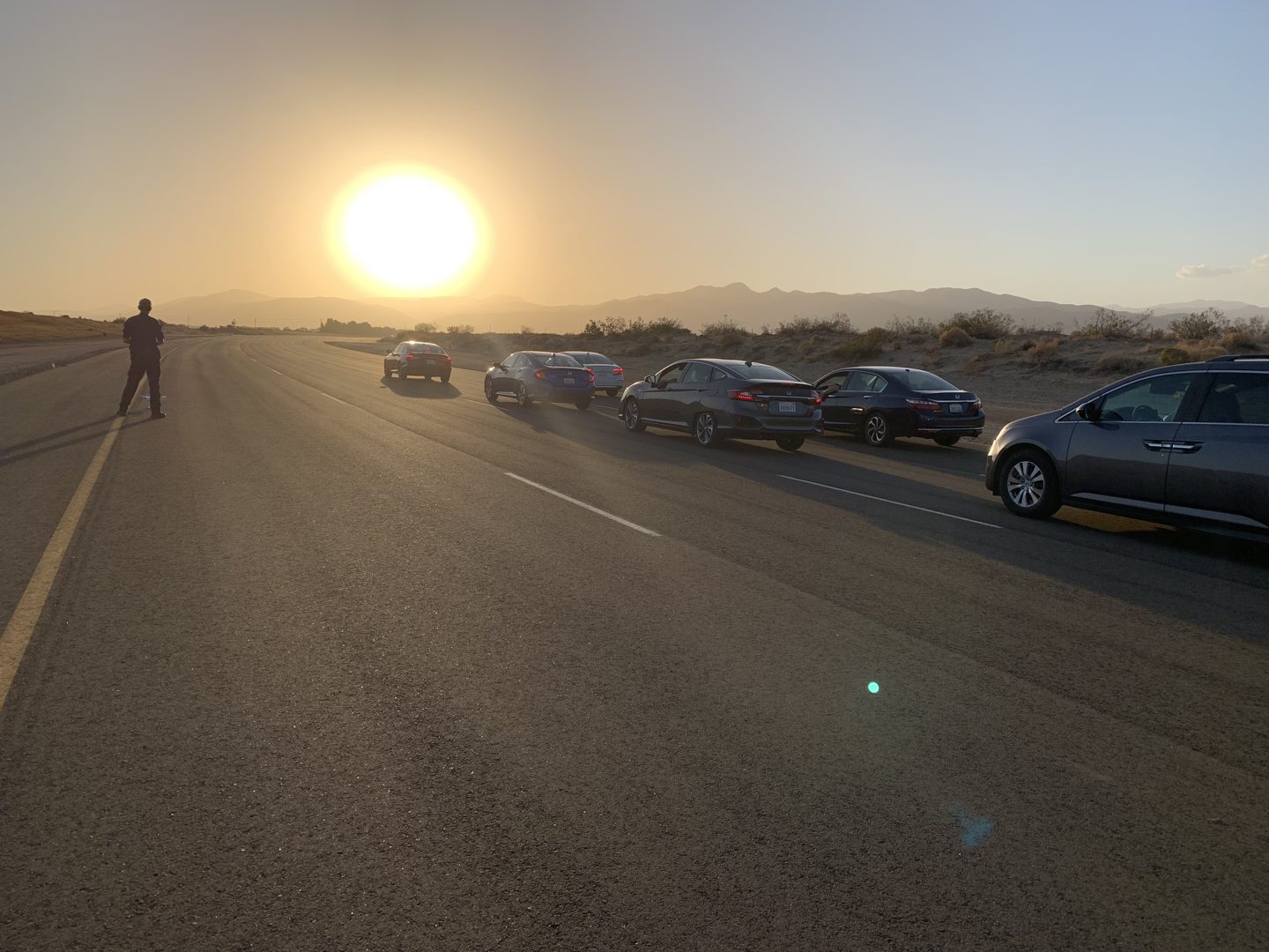 Honda vehicles lined up on a test track in low evening light