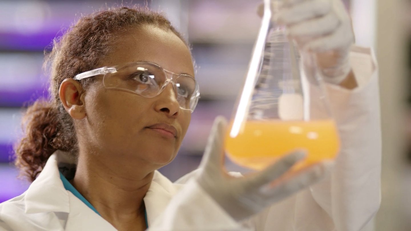 Researcher examining a flask in a laboratory