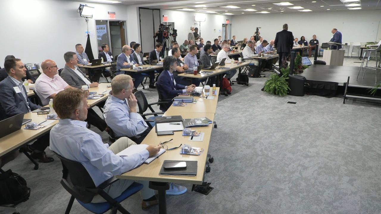 Audience seated beside the stage at THOR Investor Day, with production cameras and lighting visible around the room